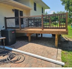 Deck with railing next to patio and AC unit